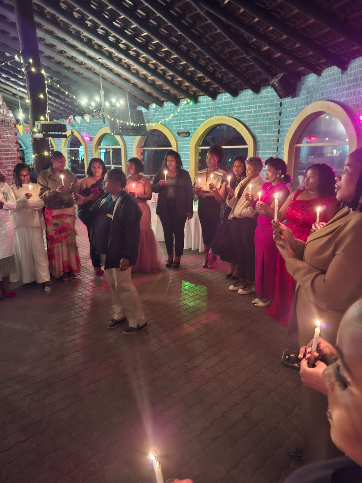 Women holding candles during ceremony